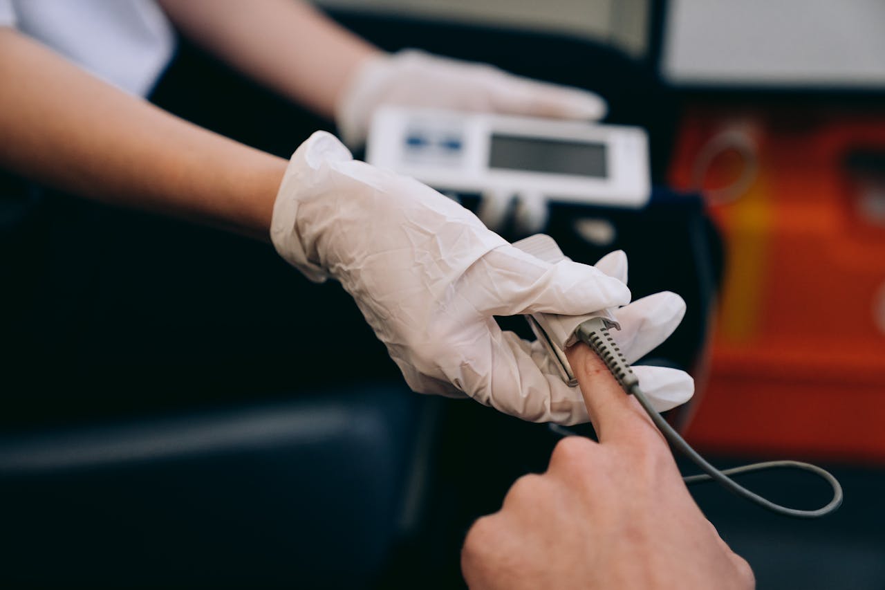 Close-up of a healthcare professional using a pulse oximeter on a patients finger to monitor vital signs.